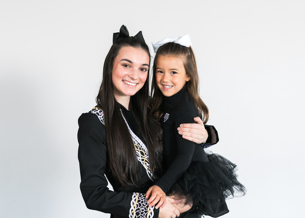 An older dancer holding a young dancer